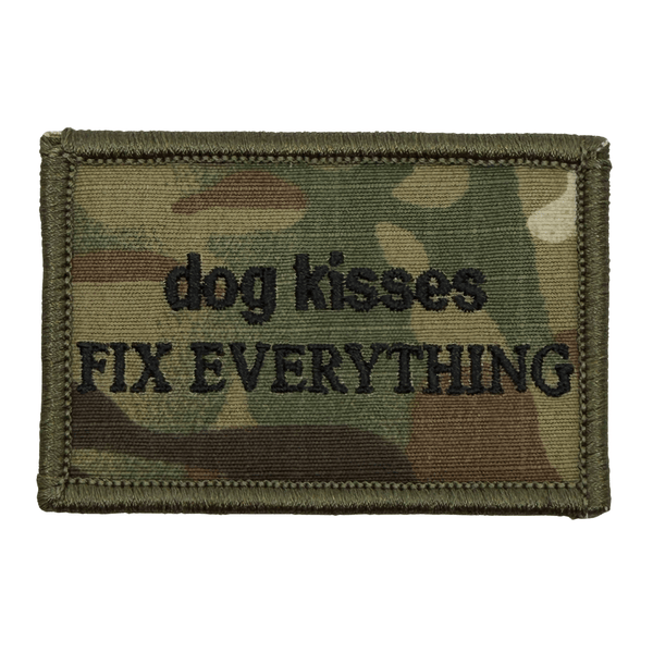Camouflage patch with 'dog kisses fix everything' in black text on a multicam camo background