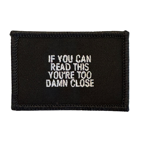 If You Can Read This You Are Too Damn Close Patch - Black-White  Embroidered Patch - Black-White,
Hook fastener backing,
Made in the USA,
2" x 3" sized for our tactical/operator caps 