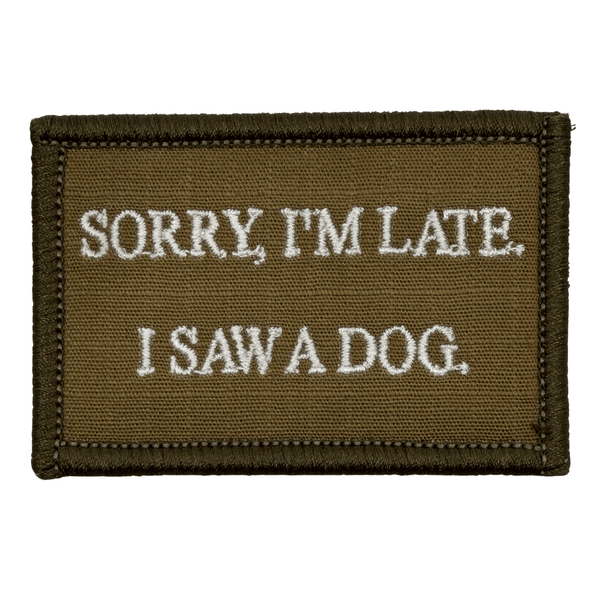 Brown Embroidered patch with white text 'Sorry, I'm late. I saw a dog.' on a white background. Hook and loop backing.